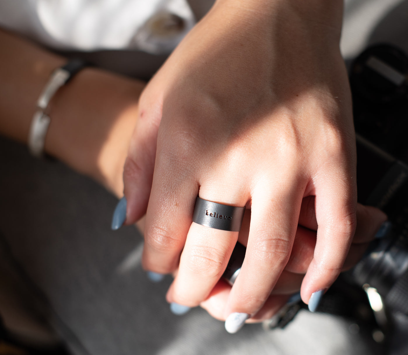 טבעת עם המילה believe בצבע שחור על דוגמן